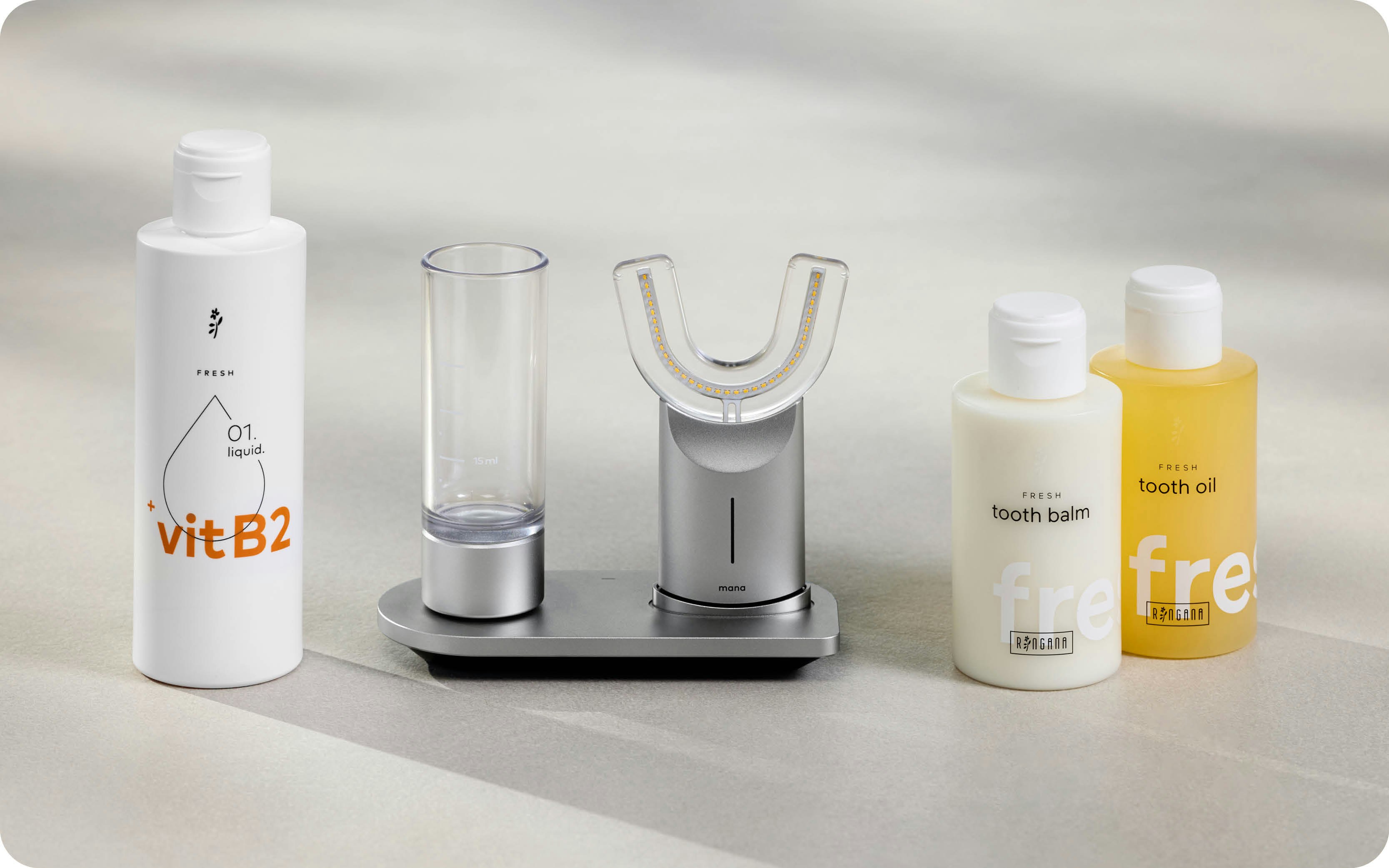 Imagefoto mit allen Produkte der RINGANA Zahnpflegeroutine für Erwachsene: manadental liquid, manadental device, FRESH tooth oil und FRESH tooth balm.